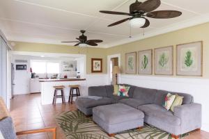 un soggiorno con divano e ventilatore a soffitto di OceanFront Kauai - Harmony TVNC 4247 a Kapaa