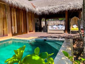 Villa mit einem Pool und einem Strohdach in der Unterkunft Charlie's Villa in Gili Air