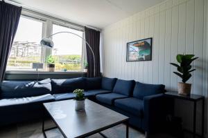 a living room with a blue couch and a table at Reine Basecamp - Apartments & Rooms in Reine