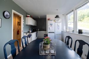 a kitchen with a black table and blue chairs at Reine Basecamp - Apartments & Rooms in Reine