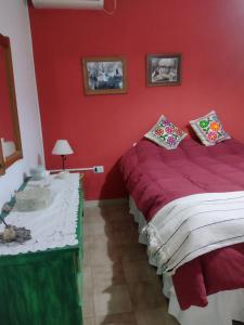 een rode slaapkamer met 2 bedden en een tafel bij La Casa de Ana in San Antonio de Areco