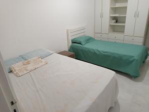 サルバドールにあるApartamento - Diária ou Curta Temporada 34の白い部屋のベッド2台 緑のシーツ