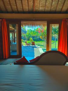 Schlafzimmer mit einem Bett und Blick auf einen Innenhof in der Unterkunft Charlie's Villa in Gili Air