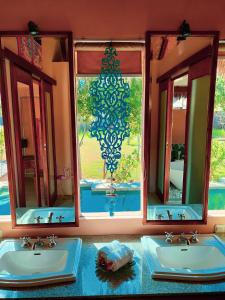 ein Badezimmer mit zwei Waschbecken und zwei Spiegeln in der Unterkunft Charlie's Villa in Gili Air