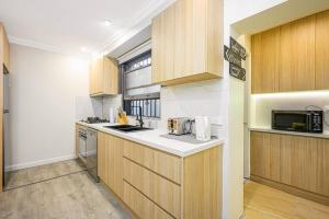 a kitchen with wooden cabinets and a counter top at Cozy 3 bedroom terrace in CBD in Sydney