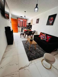 a living room with a black couch and a table at Rincón del sol depa en Manzanillo colima in Manzanillo