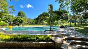 a swimming pool with a palm tree in a park at Villa Sebastiana Bungalows in Tarapoto +66 photos