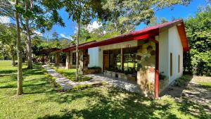 un pequeño edificio con techo rojo en un parque en Villa Sebastiana Bungalows en Tarapoto