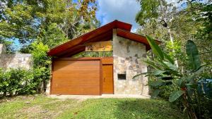 a garage with a wooden door in a yard at Villa Sebastiana Bungalows in Tarapoto