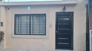 a building with a black door and a window at Complejo Consolata Mendoza in Guaymallen