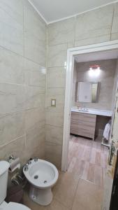 a bathroom with a white toilet and a sink at Complejo Consolata Mendoza in Guaymallen