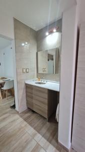 uma casa de banho com um lavatório e um espelho grande em Complejo Consolata Mendoza em Guaymallén