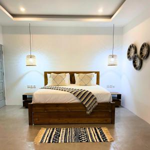 een slaapkamer met een bed met 2 lampen en een tapijt bij The Pd - Entire Holiday Home in Amed