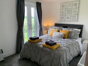 a bedroom with a large bed with yellow pillows on it at Newbus Grange Lodge The Cottage in Darlington