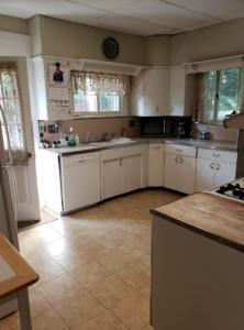 a large kitchen with white cabinets and a tile floor at Cummings Place AirBNB in Wellsville