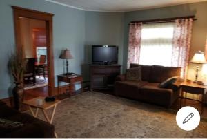 a living room with a couch and a tv at Cummings Place AirBNB in Wellsville