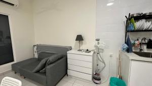ein Zimmer mit einem Sofa und einem Waschbecken in einer Küche in der Unterkunft Diamond Home Cozy at Arte Mont Kiara in Kuala Lumpur