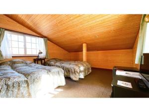 a bedroom with two beds and a wooden ceiling at Hakuba Pension Meteor - Vacation STAY 63342v in Hakuba