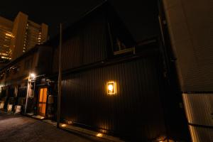 una luz en el lateral de un edificio por la noche en mist - Japanese House with Private Outdoor Sauna, en Osaka