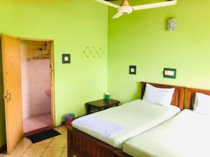a bedroom with a large bed and a bathroom at Kandyan Holiday Center in Kandy