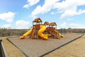 um parque infantil com um escorrega amarelo e um controle deslizante em New 3 Bedroom Vacation Home Lackland/Sea World/La Cantera em San Antonio