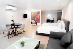 1 dormitorio con 1 cama blanca, mesa y sillas en Green Sun Hotel, en Manila