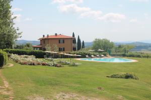 ein großer Hof mit einem Haus und einem Pool in der Unterkunft Bio Agriturismo Il Torrione in Saturnia