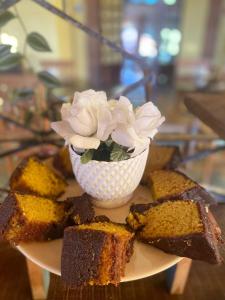 a plate with a vase of flowers and cake at Cachoeira dos Luis - Parque & Pousada in Bueno Brandão