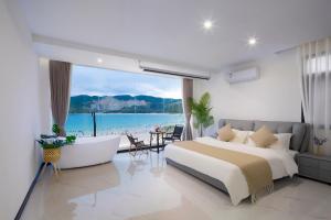 Schlafzimmer mit einem Bett und Meerblick in der Unterkunft Deer Chenke seascape Surf B&B in Sanya