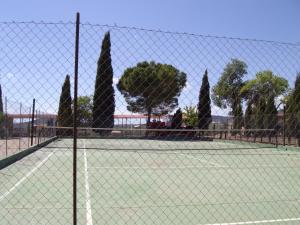 una pista de tenis con árboles y una valla en Set of rural houses in the center of Andalucia, en Humilladero