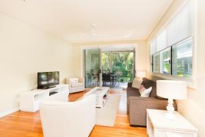 a living room with a couch and a tv at Blueys Retreat in Blueys Beach