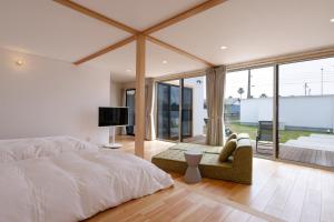 a bedroom with a bed and a tv and glass doors at VILLA SOUTH COAST SHIMA in Hamajima