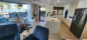 cocina y sala de estar con nevera. en Casa del Sol Caloundra en Caloundra