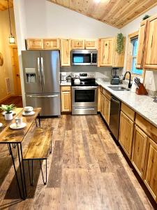 una cocina con armarios de madera y electrodomésticos de acero inoxidable en Almost Heaven Mountain Cabin, en Murphy