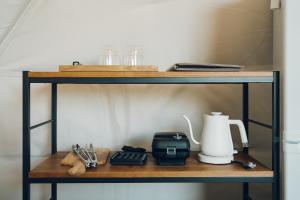 ein Regal mit einer Kaffeemaschine und einem Mixer in der Unterkunft LUONTE 霧の高原 Glamping 