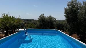 a swimming pool with a slide in the middle at Villa Colle dei Trulli Monopoli in Monopoli