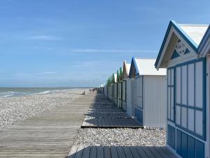 una fila de cabañas de playa en la playa en Beautiful apartment, 2 terraces, near the beach, Cayeux-sur-Mer, Baie de Somme, en Cayeux-sur-Mer