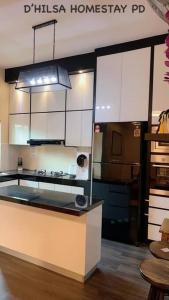 uma cozinha com um fogão e um frigorífico em D’hilsa Homestay Port Dickson em Porto Dickson