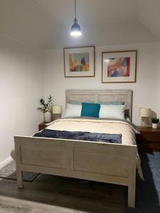 1 dormitorio con 1 cama con 2 lámparas y 2 fotografías en Zen Out on Surrey, en Alfredton