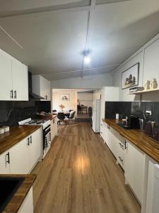 cocina grande con armarios blancos y suelo de madera en Zen Out on Surrey, en Alfredton