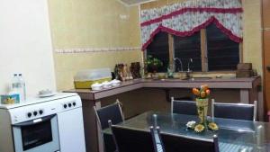 uma cozinha com uma mesa, um lavatório e um fogão em Homestay Tambun Ipoh em Tambun