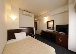 Habitación de hotel con cama y TV en Hotel Blion Naha, en Naha