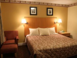 um quarto de hotel com uma cama e uma cadeira em Stardust Motel em North Stonington