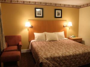 a hotel room with a bed and a chair at Stardust Motel in North Stonington