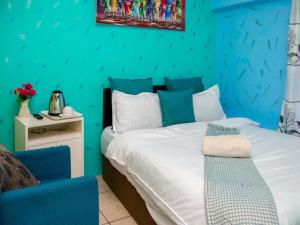 Dormitorio azul con cama y pared azul en Annex Lodge @ Ndabeni en Ciudad del Cabo