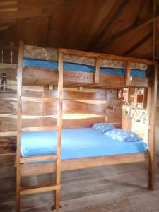 a bunk bed in a cabin with a blue bed at Sustainable, Off-Grid and Organic Cabins on a Farm in a Secluded Cloud Forest, Ultra Low Carbon Footprint in Puntarenas