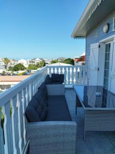 a patio with a couch and chairs on a balcony at Lindsey Hôtel in Saint-Pierre