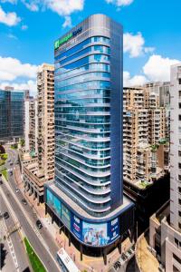 un edificio alto de cristal en una ciudad con tráfico en Holiday Inn Express Macau City Centre, an IHG Hotel en Macao