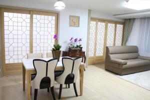 a living room with a table and chairs and a couch at Geoje Residence Hotel in Geoje