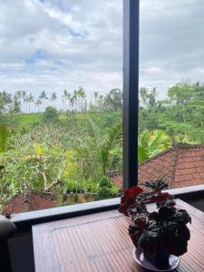 a room with a table with a view of a garden at Twin Inn in Ubud